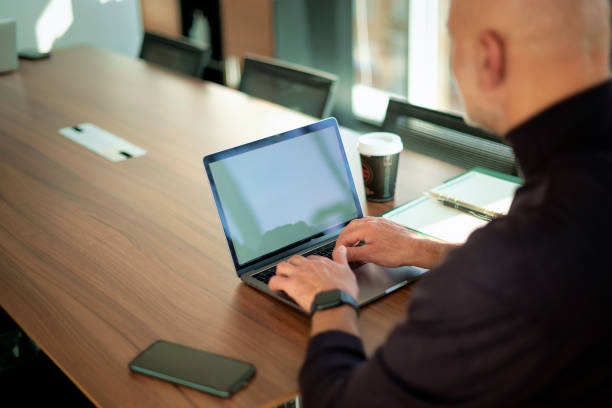 istock Executive businessman sitting at the office desk and using his laptop 2195111173