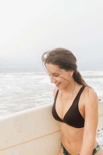 istock Smiling surfer with surfboard on sea shore 2195111870