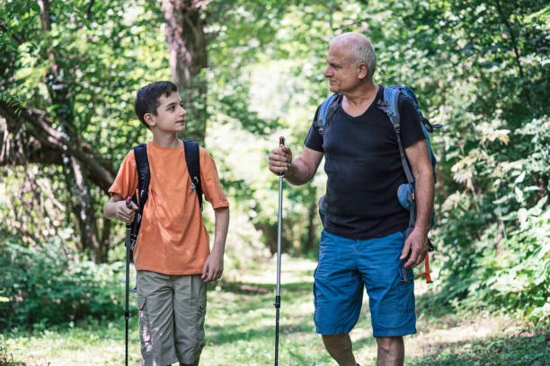 istock Hikers walk together in lush verdant forest trail. 2195112098