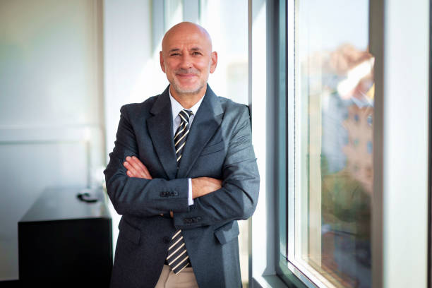 istock Businessman standing in a modern office with folded arms 2195115148