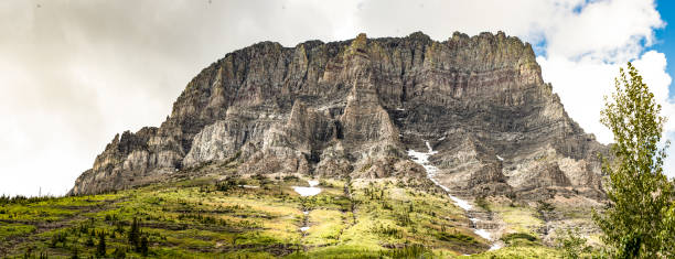 istock Sunlit Rockface in Glacier National Park Surrounded by Verdant Vegetation 2195115193