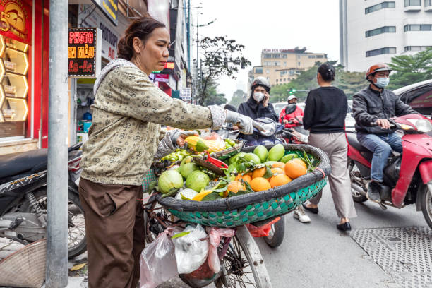 Hanoi, Vietnam - March 22, 2024: A Vietnamese woman sells fruit on the street on the Weekend Walking Street in Hanoi