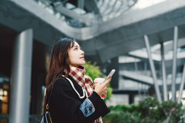 istock Young asian girl using smartphone in the city. 2195116093