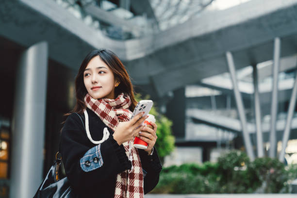 istock Young asian girl using smartphone in the city. 2195116105