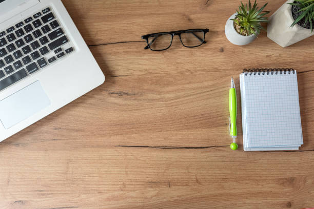 istock Workplace with laptop, empty notepad  office supplies on office desk. Creative background 2195116374