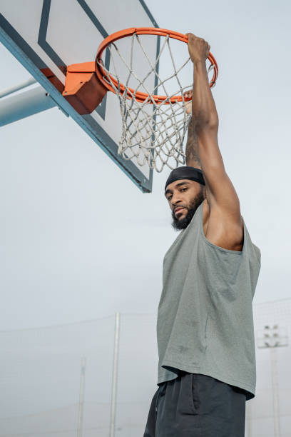 istock Basketball player hanging on the basket after scoring a point 2195116445