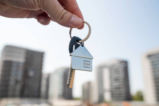 istock A person holds keys in front of a building that is currently under construction 2195116493