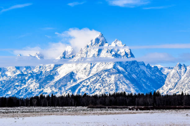 Wind blows the snow off the mountain peaks at Grand Teton National Park, Wyoming.