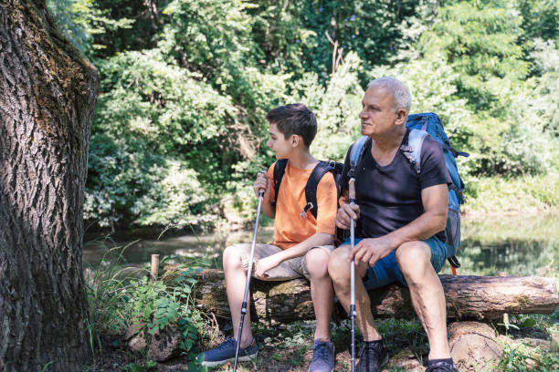 istock Two hikers resting on a log in a serene forest 2195118079