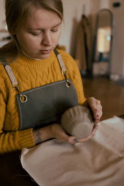 istock Focused woman molding clay by hands working in studio 2195118537