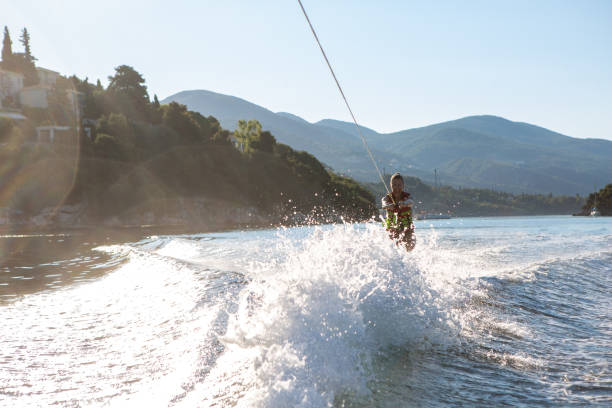 Young man surfs on a lake using a water ski lift