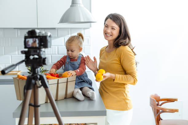 istock Mother and daughter filming cooking video in modern kitchen 2195122105