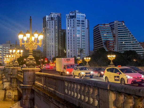 Valencia, Spain - December 19, 2024: Traffic across bridge at night. The dried riverbed of the Turia river is crossed by many bridges that allow to move from one side to the next of it