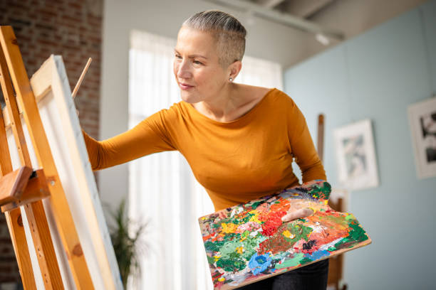 istock Artist engaged in vibrant painting in an art studio filled with natural light while exploring creativity 2195123357
