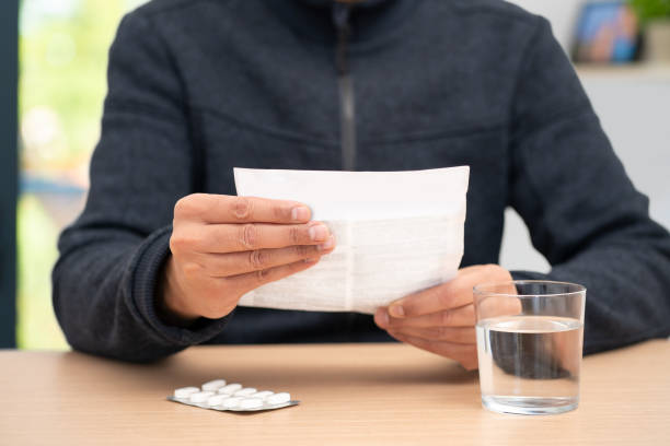 istock man holding a leaflet and reading at the table in his home 2195125065