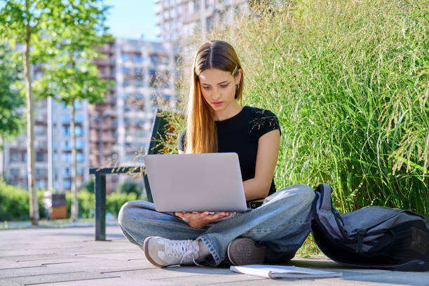 istock Young female college student typing on laptop computer outdoor 2195127762