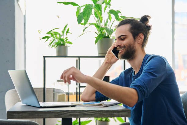 istock Smiling young handsome man talking on mobile phone 2195129090
