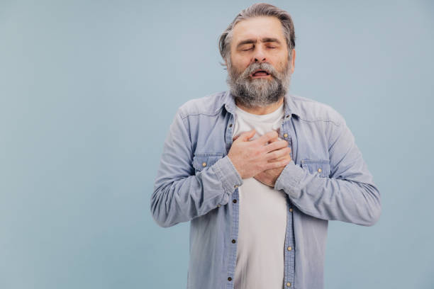 istock Senior man suffering chest pain on blue background 2195132184