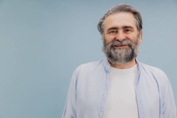 istock Smiling Senior Man with Beard Posing on Blue Background 2195133345