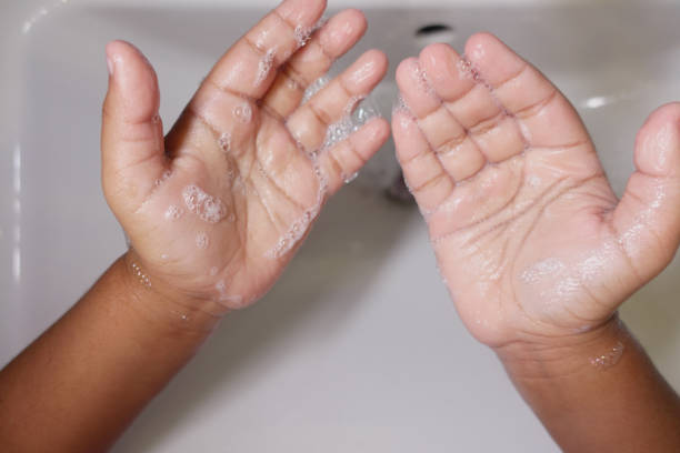istock child making a cleansing gesture with soap and water on hands 2195135063