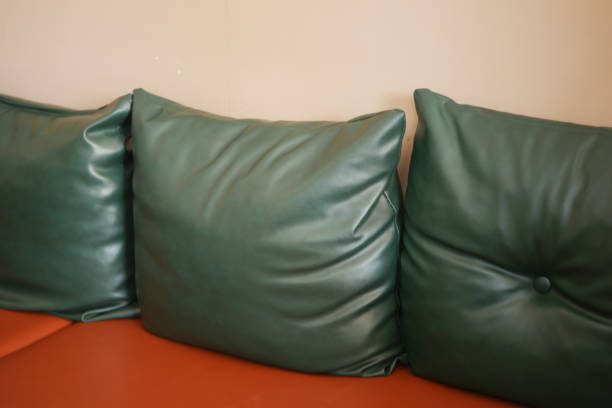 istock Green Leather Cushions rest elegantly on a vibrant Orange Couch, a stylish seating choice 2195135215