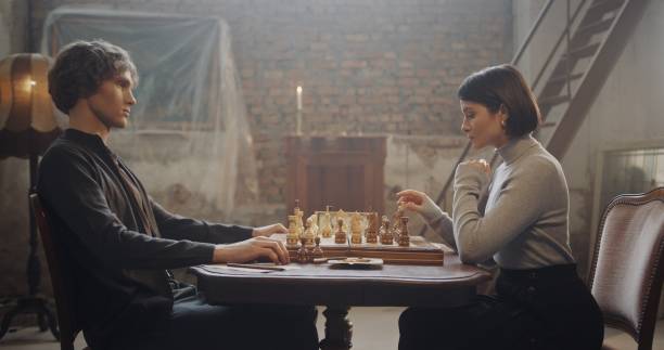 istock Focused Chess Match Between Young Man and Woman in Vintage Loft Setting 2195135438