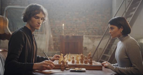 istock Focused Chess Players Analyzing Moves in a Rustic Vintage Setting 2195135734