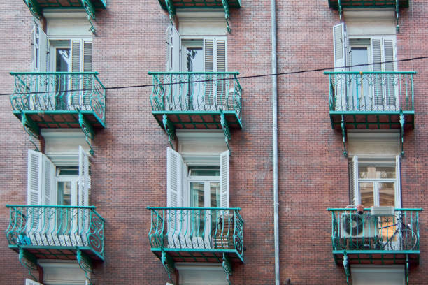 Madrid. Spain - January 21, 2025: Detailed view of a historic building in Madrid, highlighted by its six green balconies with intricate ironwork and white shutters.