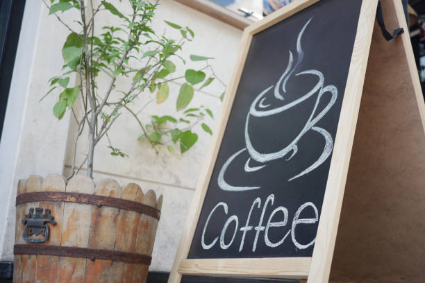 This charming coffee shop sign features an inviting illustration of a steaming cup of coffee