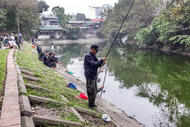 Hanoi, Vietnam - March 22, 2024: Many Vietnamese people fishing in Thien Quang Lake