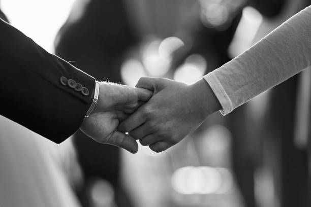 istock Close-Up of Two People Holding Hands, Emphasizing Connection and Support 2195145113