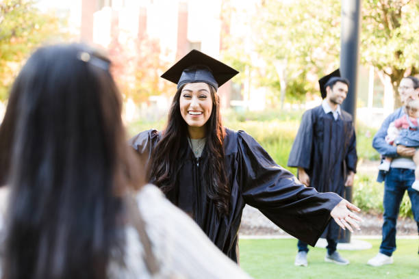 istock Happy Graduate in Cap and Gown Giving a Hug 2195149771