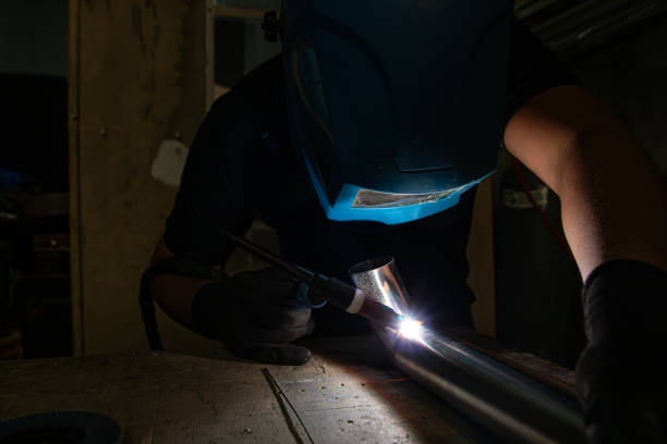 istock Operator Using TIG Torch to Weld Metal Tube with Safety Gear 2195152105