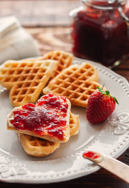 Heart shaped homemade Belgian waffles with strawberry jam for Valentine's Day