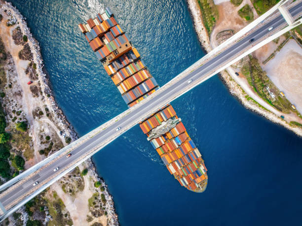 istock Aerial view of a large container cargo ship passing under a bridge 2195155564