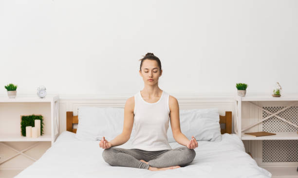 istock Meditation Concept. Woman Practicing Yoga On Bed 2195156197