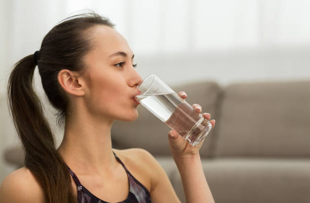 istock Woman Drinking Clean Water From Glass After Training 2195156210