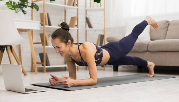 istock Woman Performs Plank Exercise at Home While Following Online Workout During Morning Routine 2195156253