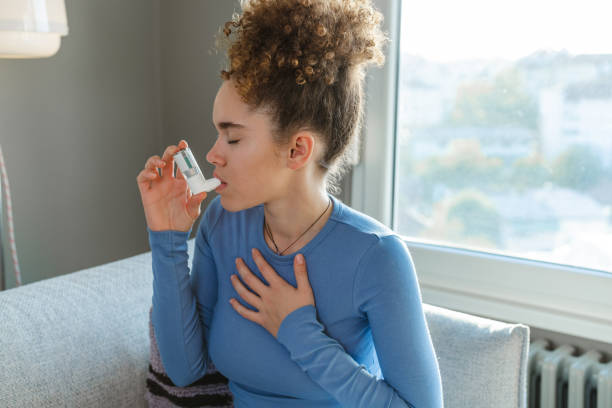 istock Young woman using an inhaler to soothe her breathing difficulty indoors 2195157706