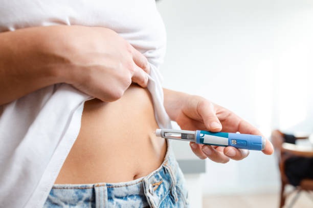 istock Person administering insulin injection using a pen 2195158078