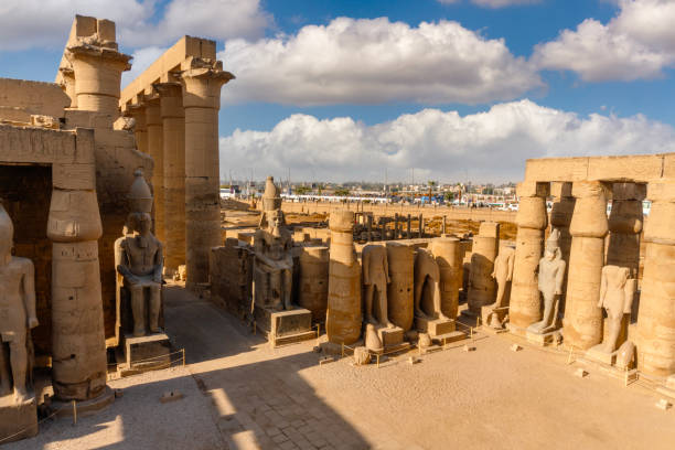 Luxor temple showing ancient egyptian artifacts under partly cloudy sky
