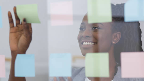 istock Creative Professional Organizing Thoughts With Sticky Notes on Glass in Modern Office Environment 2195160315