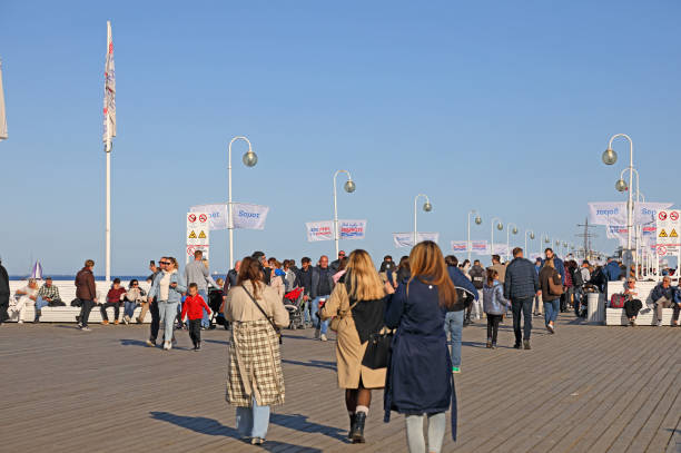 Sopot, Poland - October 12, 2024: People walk along the longest wooden pier on the Baltic Sea on a sunny autumn day.
