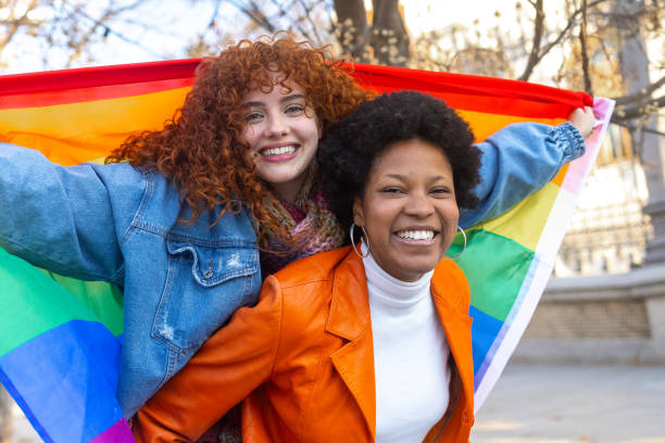 istock Two smiling women holding rainbow flag celebrating lgbt pride 2195166193