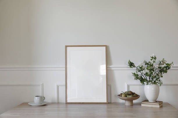 istock Springtime breakfast still life. Empty vertical picture frame poster mockup. White ceramic vase with blooming apple tree branches. Cup of coffee, tea, bowl, pear fruit on wooden table. Scandi interior 2195168503
