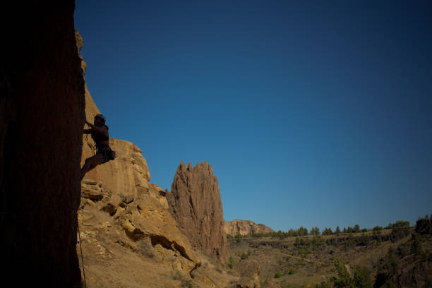 A single rock climber is silhouetted as they climb a rock face at Smith Rock State Park in Central Oregon