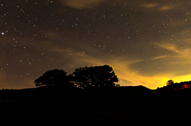 istock Stars twinkle brightly over tranquil landscape at night in serene countryside setting 2195173710