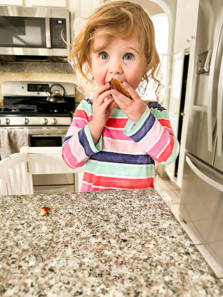istock Toddler eating and cooking in a learning tower in the kitchen 2195175432