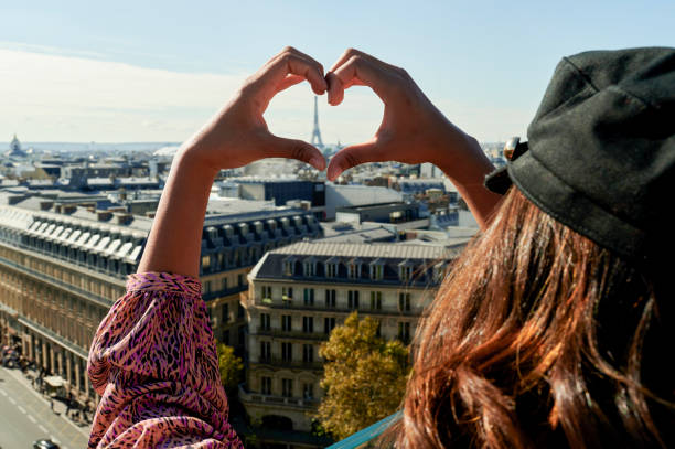 istock Woman making a heart with her hands with the Eiffel tower in the middle 2195182298