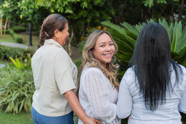 Three latin american women walking and talking in a park